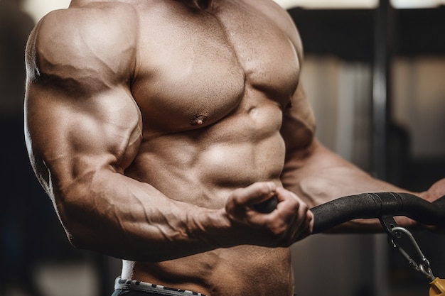 Premium Photo | Strong athletic men pumping up muscles doing workout ...