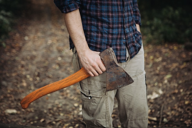 Premium Photo | Strong bearded woodcutter holding an ax in the woods