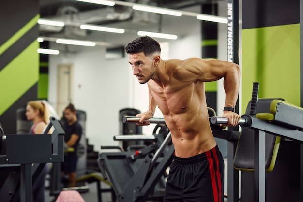 Premium Photo | Strong healthy man doing push-ups on parallel bars ...