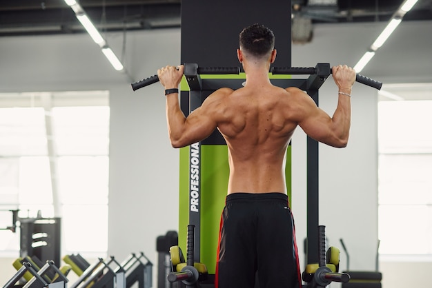 Download Strong young man does pull-up on the crossbar during ...