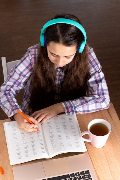 Note making. Чтение в наушниках. Чтение книги в наушниках. Девушка в наушниках читает книгу. Книга и наушники.