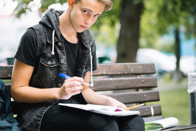 Student on bench with notepads Photo | Free Download