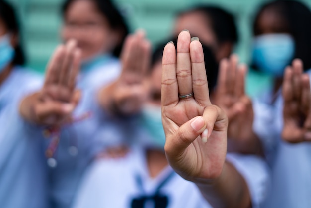 学校で3本の指の敬礼を示す学生の女の子 プレミアム写真