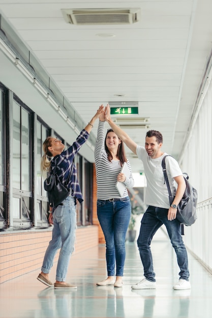 Students giving high five in hall | Free Photo