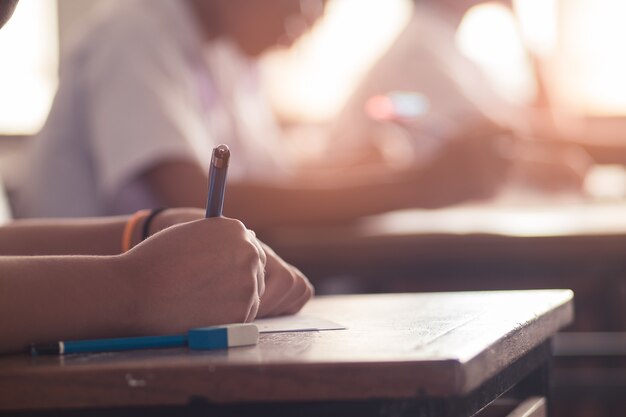 Premium Photo | Students writing answer doing exam in classroom