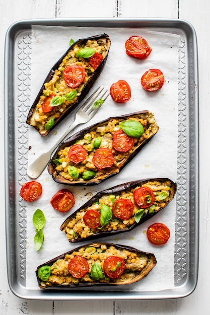 Premium Photo | Stuffed roasted eggplant boats with tomatoes