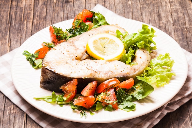 Premium Photo | The sturgeon steak with salad and lemon on the plate