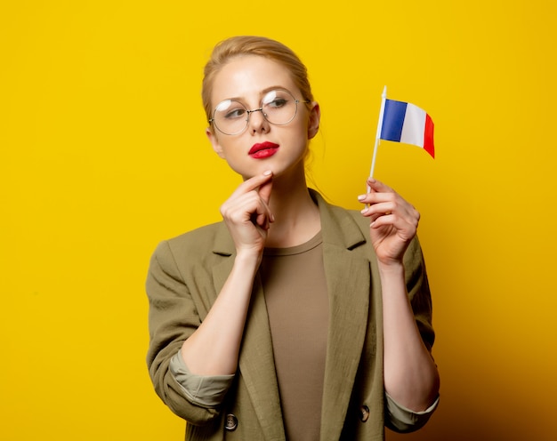 Style blonde woman in jacket with french flag on yellow Premium Photo