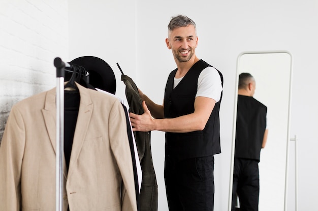 Free Photo | Stylish man holding clothes and looking away