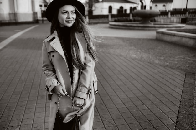 Premium Photo Stylish Young Woman In A Beige Coat And Black Hat On A City Street Black And White Photo Autumn Clothing Urban Style