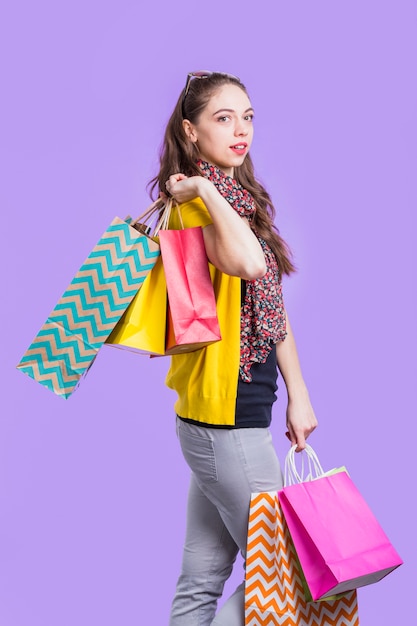 Download Stylish young woman carrying colorful paper bag | Free Photo