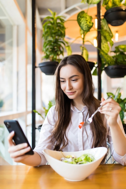 Free Photo | Stylish young woman eating healthy salad on a restaurant ...