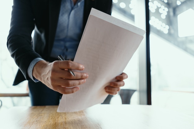 Successful business man signing documents in a modern office Free Photo