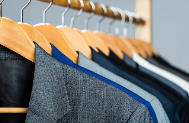 Premium Photo | Suits for men hanging on the rack.
