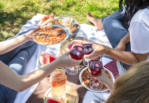 自然の中で友達と食べ物や飲み物を楽しみながら夏のピクニック 無料の写真