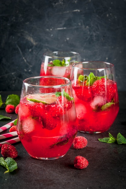 Premium Photo Summer Refreshing Non Alcoholic Cocktails Fruit Drinks Raspberry Mojito Lemonade With Fresh Organic Mint And Lime On A Black Stone Table Copy Space