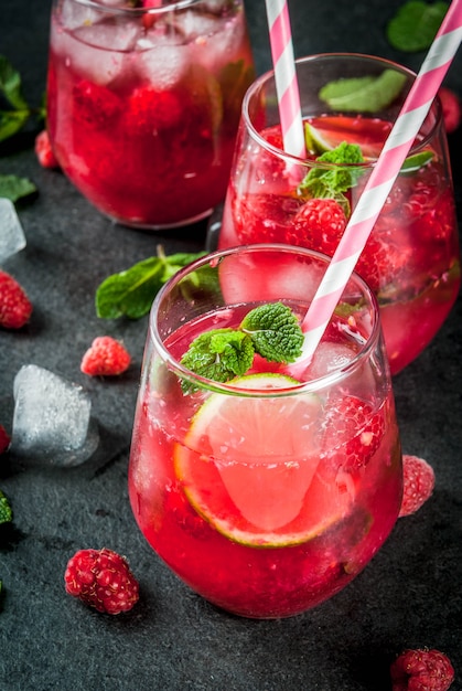 Premium Photo Summer Refreshing Non Alcoholic Cocktails Fruit Drinks Raspberry Mojito Lemonade With Fresh Organic Mint And Lime On A Black Stone Table Copy Space