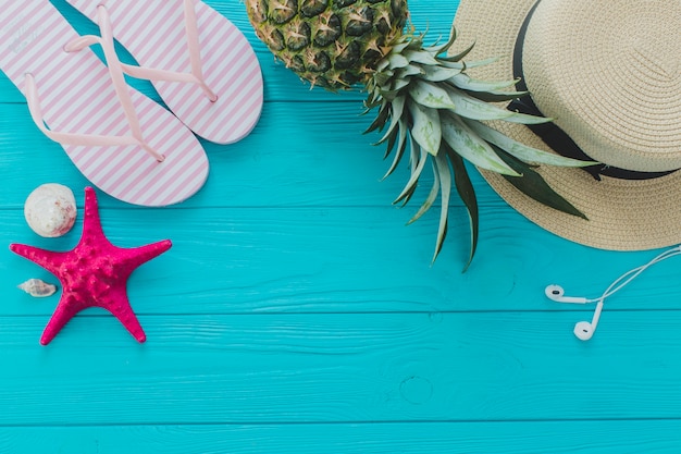Free Photo | Summer surface with pineapple, flip flops and hat