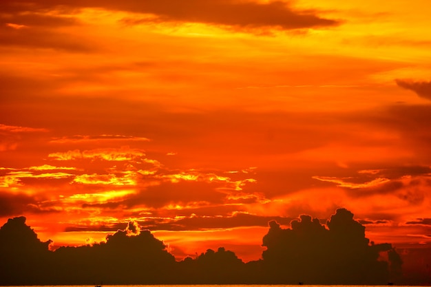 プレミアム写真 最後の光赤オレンジ空シルエット雲に沈む夕日