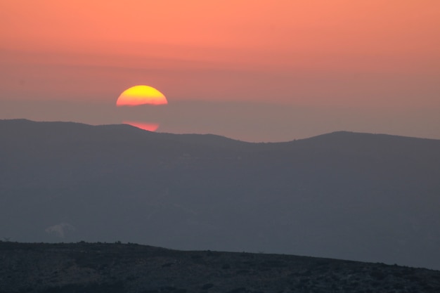 Premium Photo | Sunset on the mountain, sun setting behind the mountain.