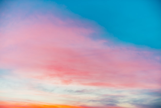 ピンクオレンジの光雲と夕焼け空 カラフルな滑らかな青空のグラデーション プレミアム写真