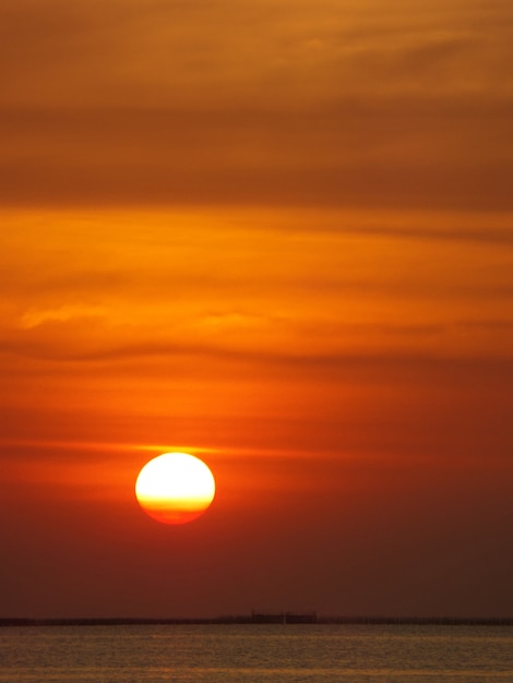 海と夕方の雲の空の背景にサンセットサンドーン プレミアム写真