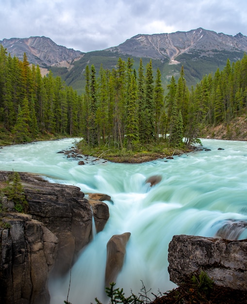 Premium Photo | Sunwapta falls with blue water flowing in spring ...