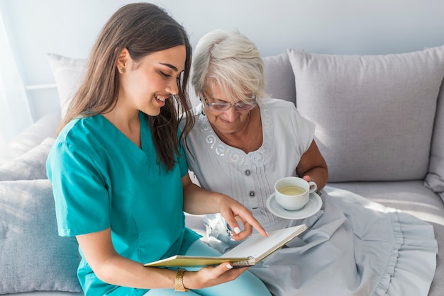 premium-photo-supportive-young-carer-sitting-with-older-patient