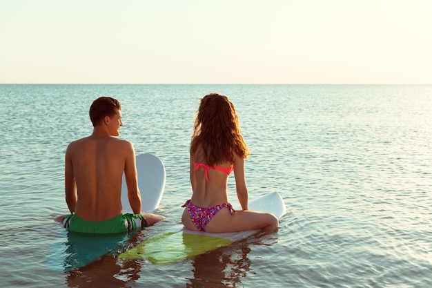 Premium Photo Surfing Couple Leaning On Surfboards In Sea 3188