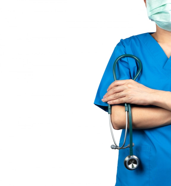 外科医の医者は青いスクラブシャツの制服と緑のフェイスマスクを着用します 医師は腕を組んで 聴診器を持っている手に立ちます 医療専門家 プレミアム 写真