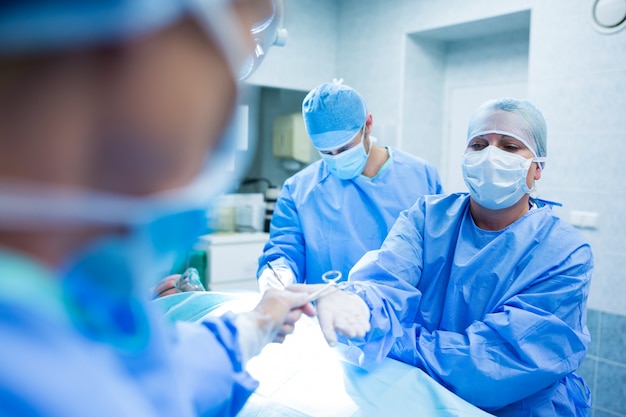 Surgeons performing operation in operation room Free Photo