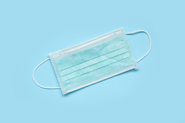 Premium Photo | Surgical face mask on blue surface