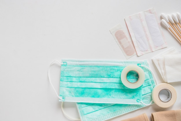 Surgical mask; bandage; cotton swabs and sticky bandage on white background Free Photo