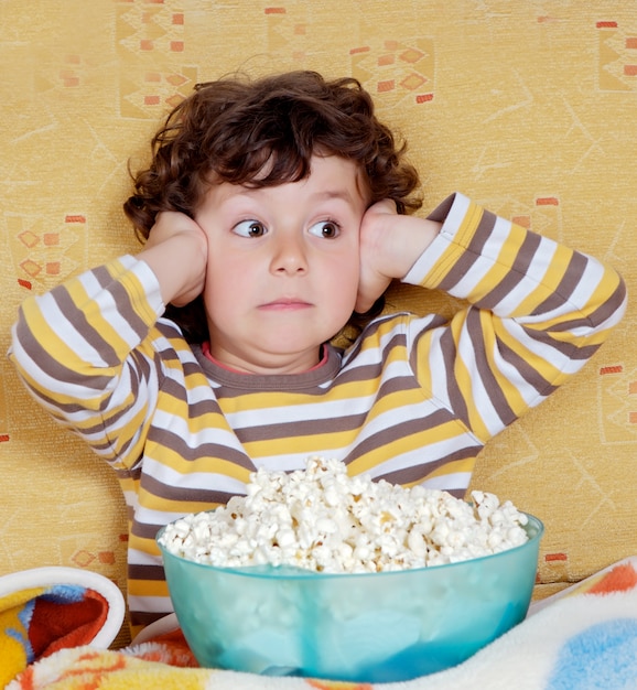 Surprised child with a bowl full of popcorn Premium Photo