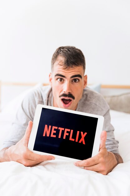 Download Free Surprised Man Showing Tablet With Netflix Logo Free Photo Use our free logo maker to create a logo and build your brand. Put your logo on business cards, promotional products, or your website for brand visibility.