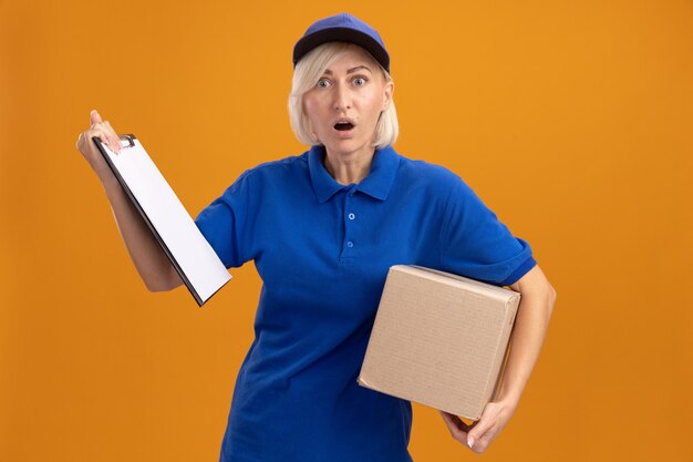 Free Photo Surprised Middle Aged Blonde Delivery Woman In Blue Uniform And Cap Holding Cardbox