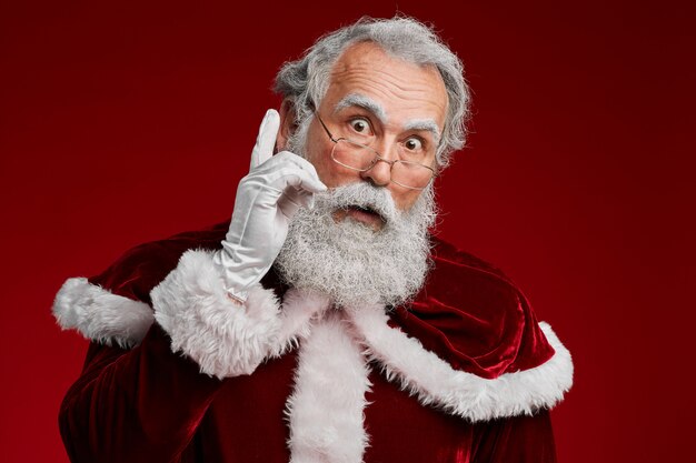 Premium Photo | Surprised santa claus on red