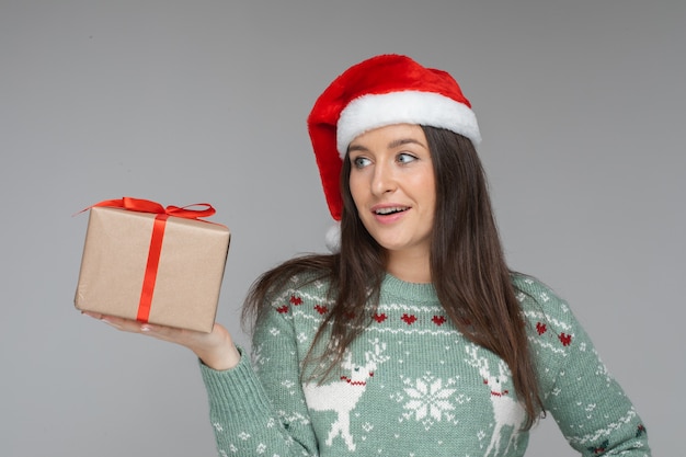 Free Photo | Surprised young girl in santa hat with gift