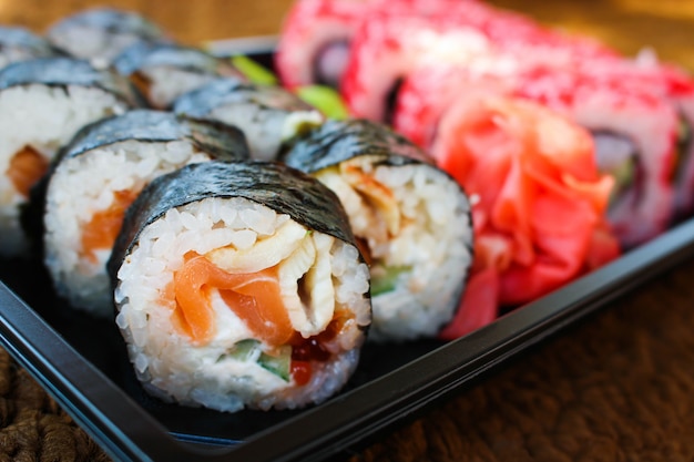 Sushi roll with salmon, cucumber, cheese, and caviar fish