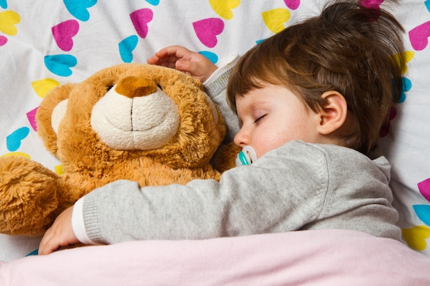 cute baby sleeping with teddy