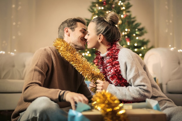 Sweet Couple Kissing While Preparing Christmas Decorations Photo