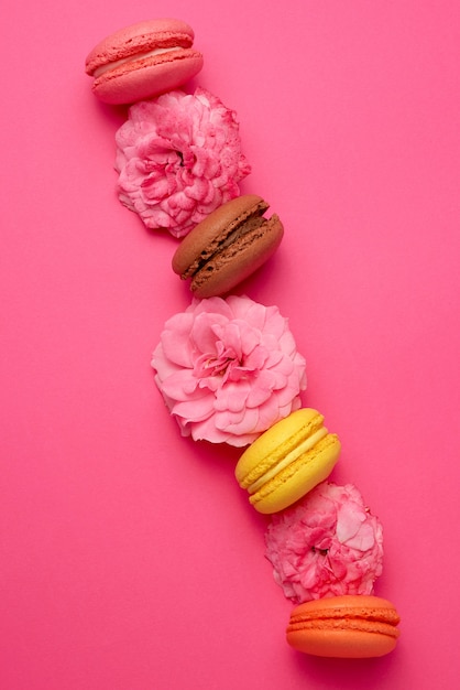 Premium Photo | Sweet multi-colored macarons with cream and pink rose buds