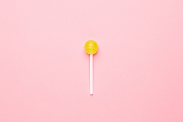 Premium Photo | Sweet yellow candy lollipop on pastel pink. minimalist ...