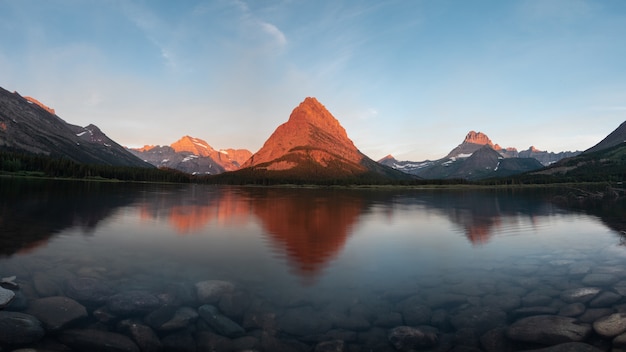 Premium Photo | Swiftcurrent lake with reflection of mountain sunrise