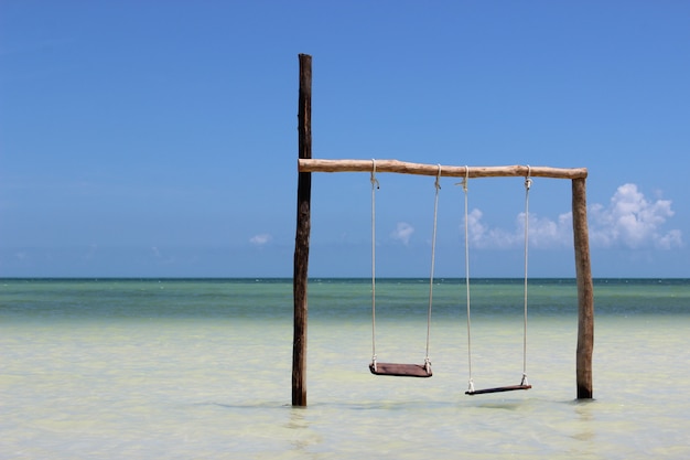 Premium Photo | Swings over water on the sea coast