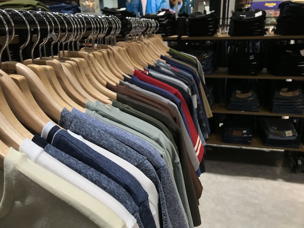Premium Photo | T shirts hanging on a rack for sale.