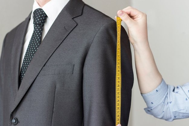 The tailor takes measurements from the suit, white background, isolated ...