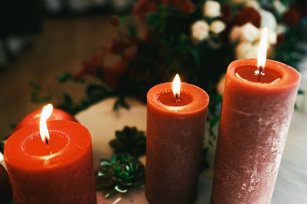 Tall red candles burn standing on white table Photo | Premium Download