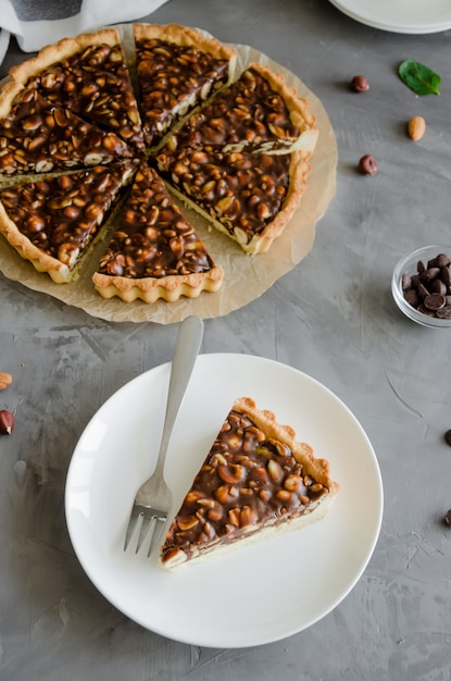 Premium Photo Tart With Chocolate Caramel Hazelnuts Peanuts Almonds And Seed Mix