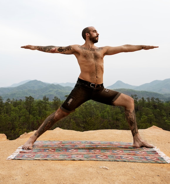 Premium Photo | Tattooed man yoga outdoors concept